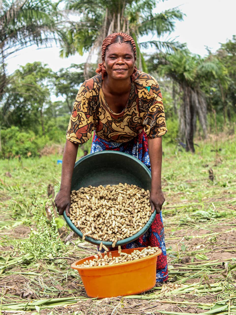 Mwanga Failla Louise (35) measures harvested groundnuts following collective production at the Tukankamane farmer field school in Kabanda, Kabalo Territory, Tanganyika. Photo: Concern Worldwide
